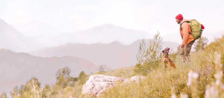 owner and dog hiking together