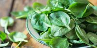 bowl of fresh spinach on table