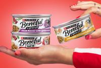 Dog licking lips as two hands open a can of Kicthen Creations.