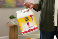 Humano sosteniendo la arena ligera Tidy Cats con su dedo meñique.