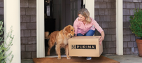 A woman and a dog with a box from Pro Plan Vet Direct home delivery