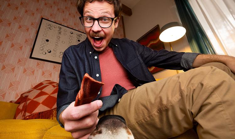man holding Beggin’ strip out for dog