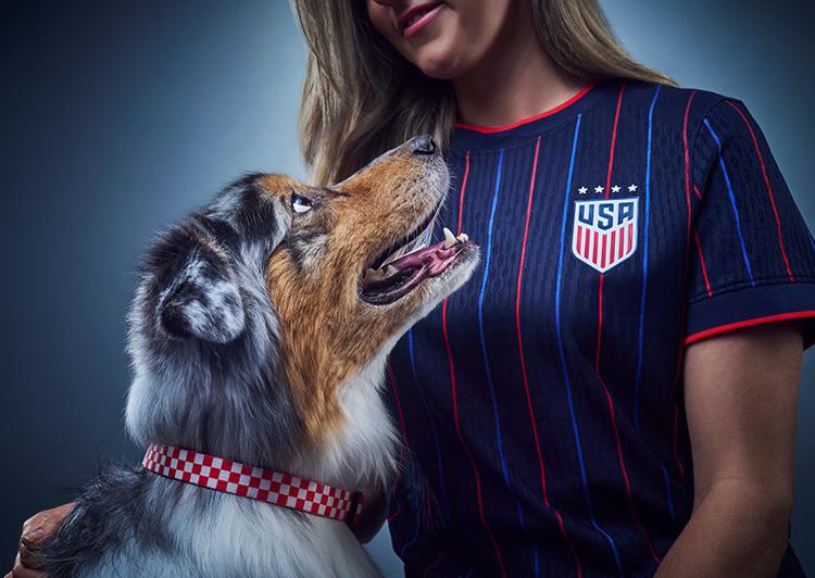 woman in team USA jersey petting dog