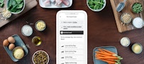 Pet Food Finder App on smart phone with ingredients surrounding it